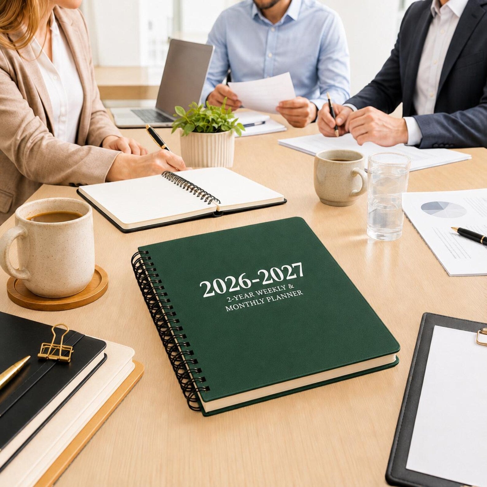 Green 2026 2027 spiral planner on meeting table for professional work planning business schedules and productivity