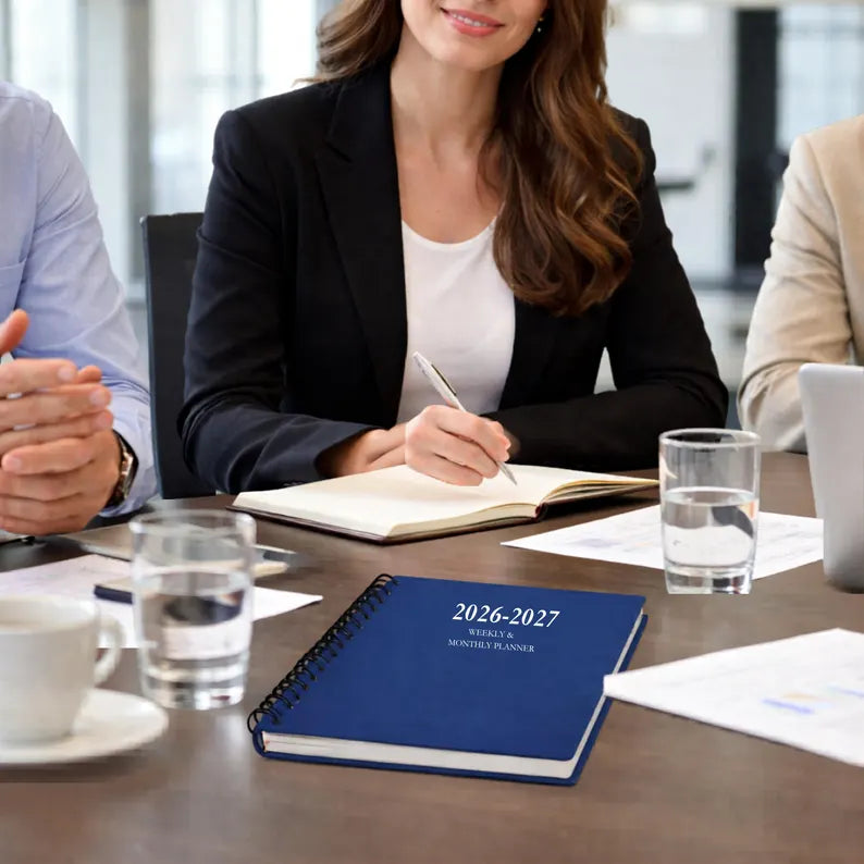 Navy blue 2026 2027 spiral planner on business meeting table for professional work planning and productivity